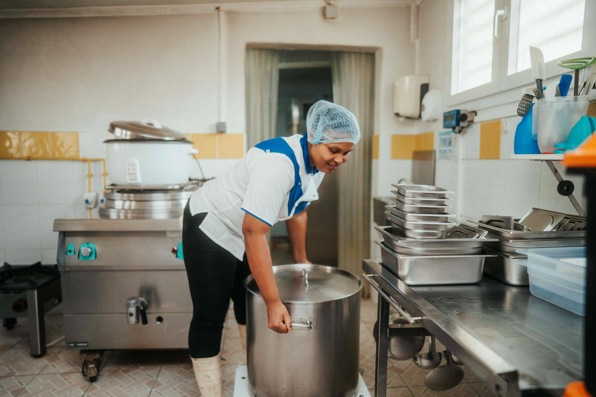 Christelle en train de déplacer une marmite