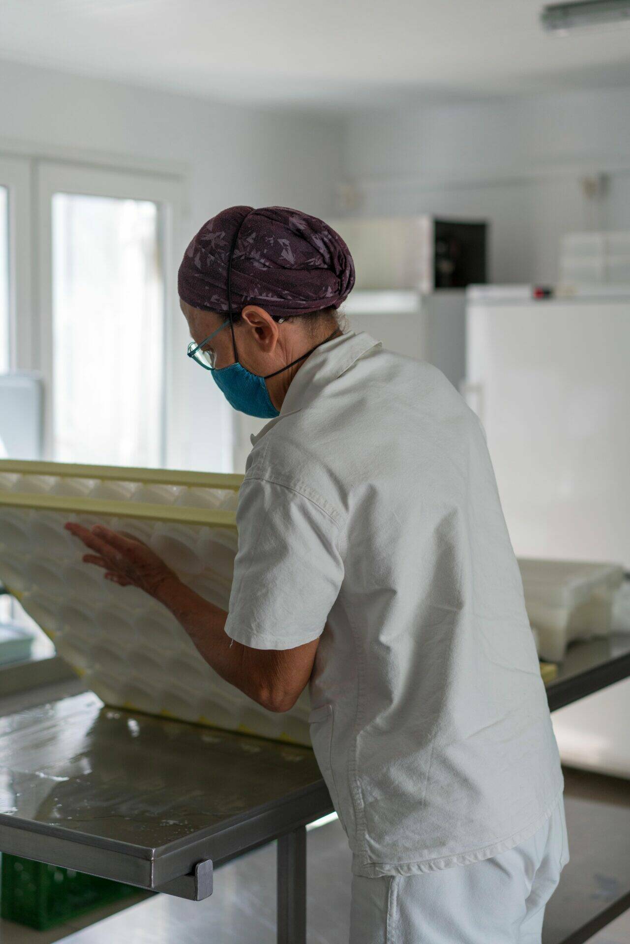 Magali dans son atelier retourne des fromages