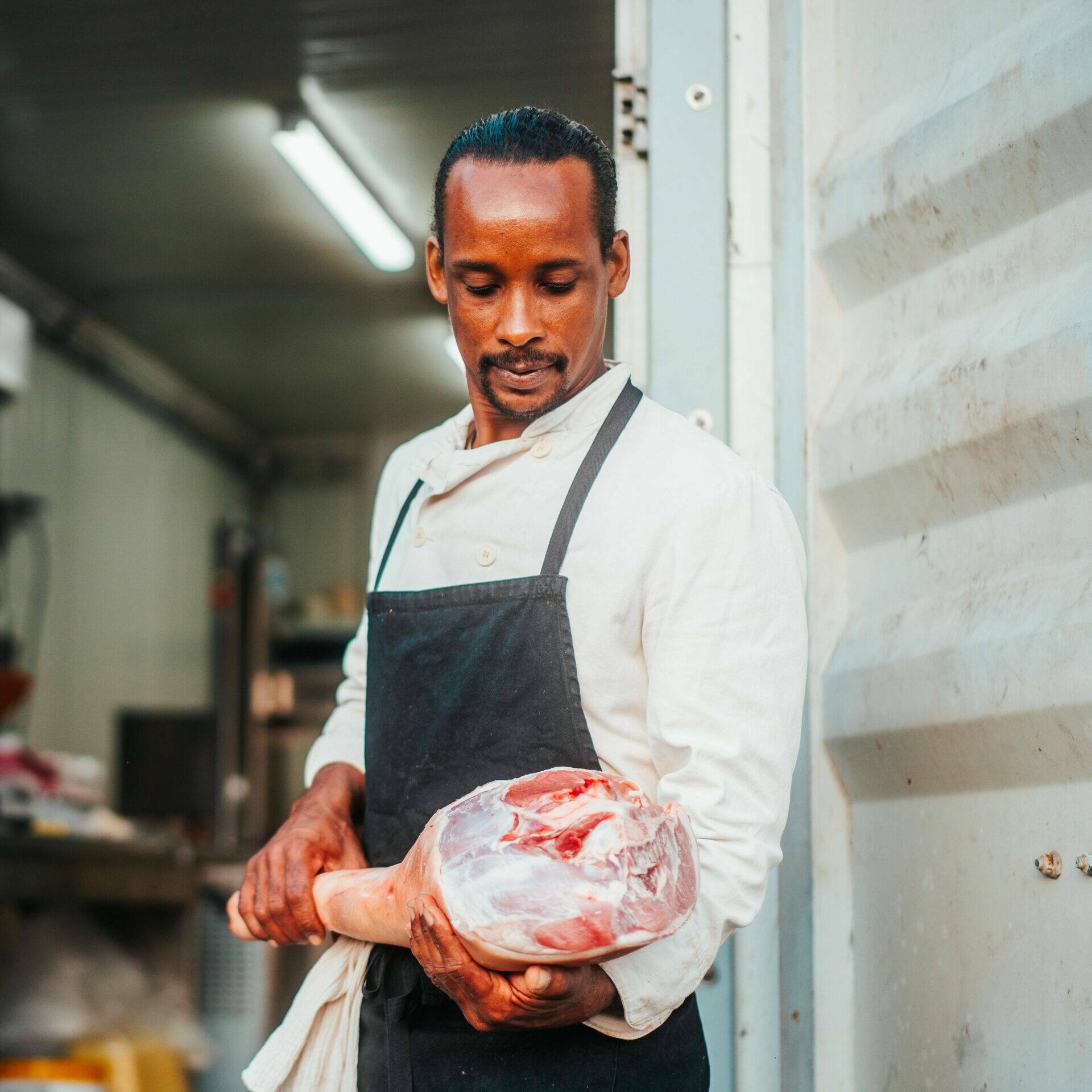 Renaud découpe de la viande de porc