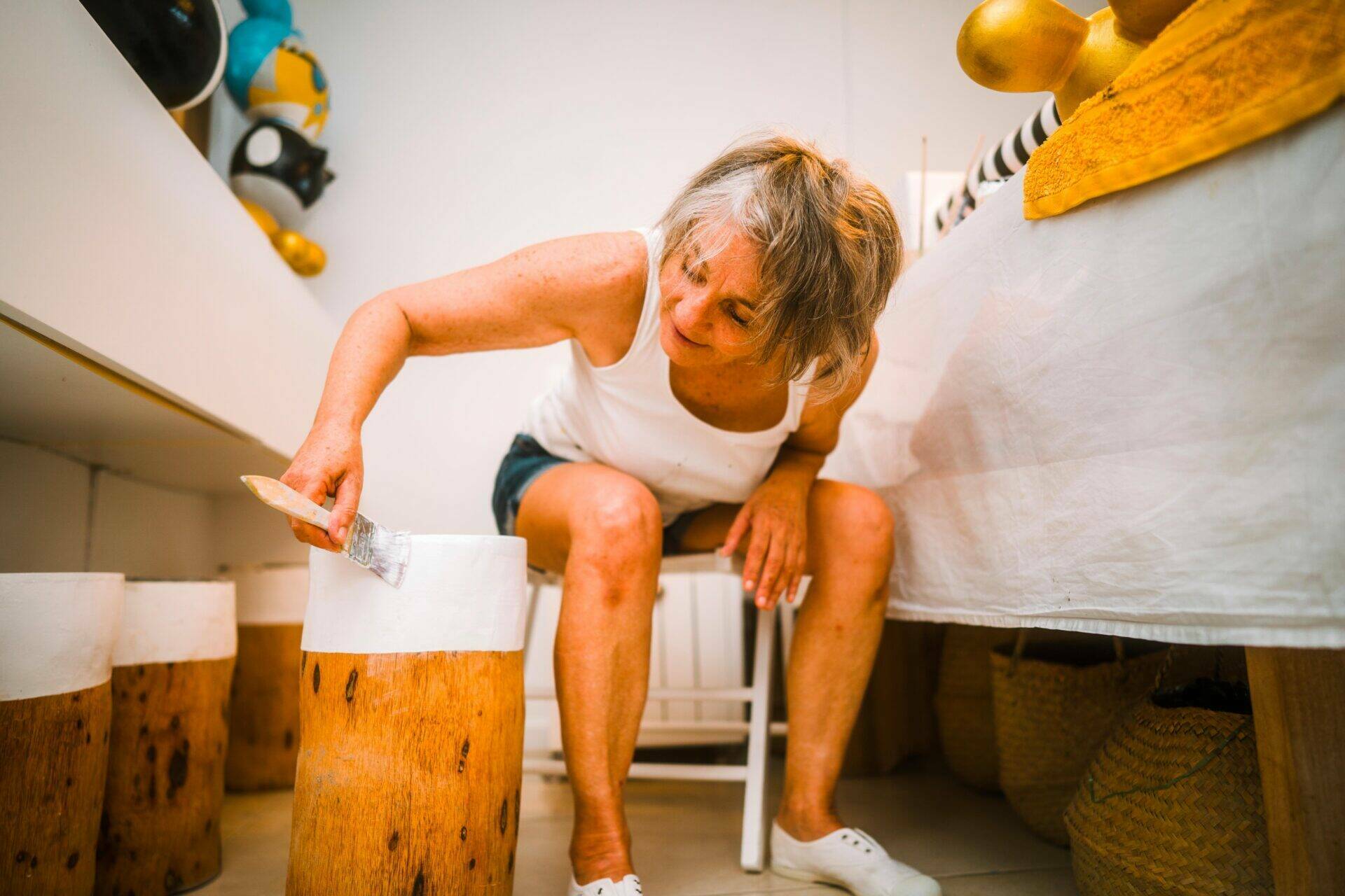 Jane en train de peindre le tabouret en cocotier