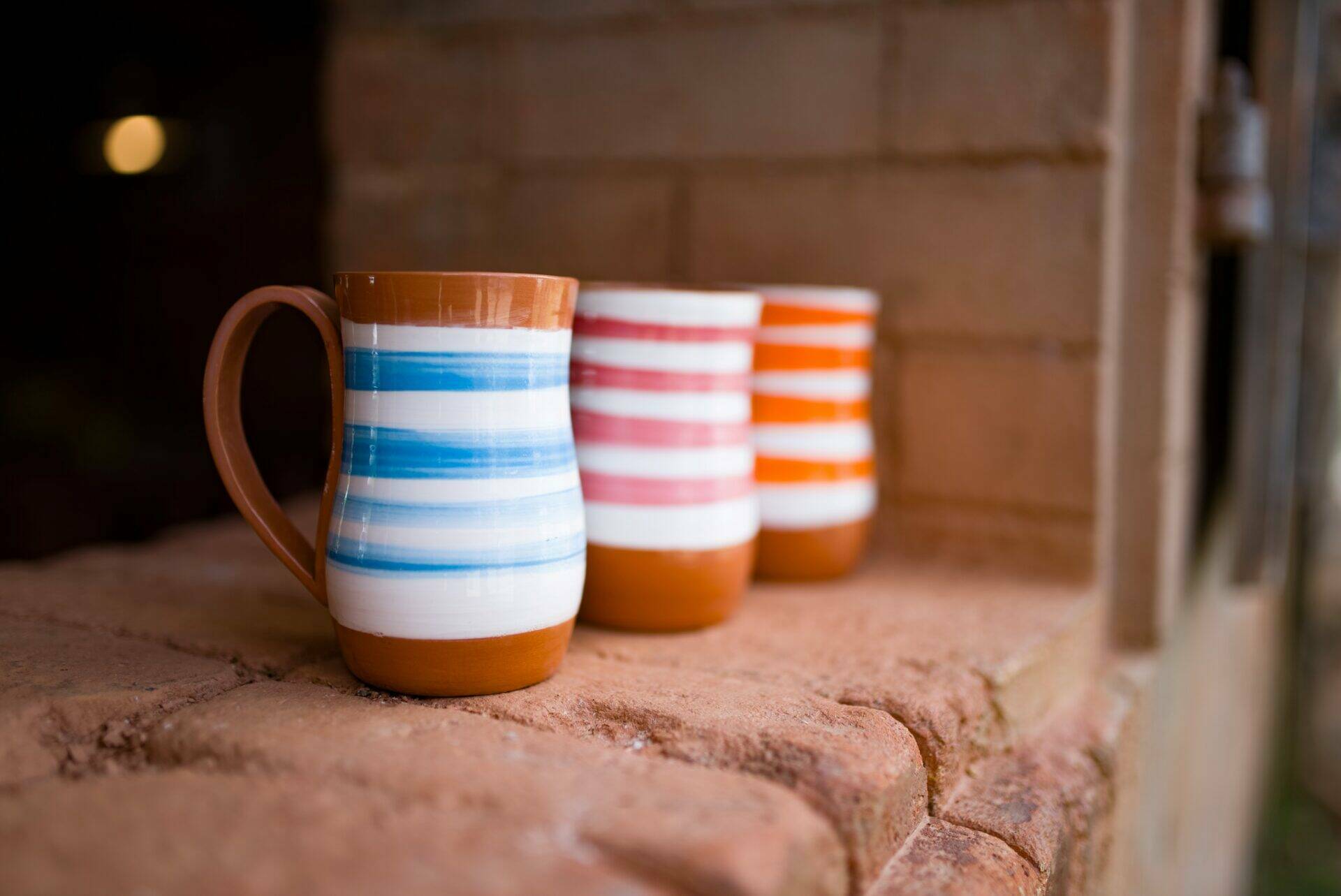 Plusieurs mugs sur le bord d'une fenêtre